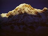 205 Annapurna South At Sunrise From Annapurna Sanctuary Base Camp Annapurna South was one of the first mountains to receive the rising sun at Annapurna Sanctuary Base Camp. Modi Peak [Annapurna South] from the Sanctuary looked impregnable. Steep, furrowed ice flutings led up to summit cliffs capped by bulging ice walls that threatened to engulf any midget men struggling on the lower slopes. The wall between the two mountains was ploughed with ice flutings that swept down gracefully between angular rock buttresses; its turreted crest was dominated by the Fang, well-named, for it was shaped like the tooth of a wolf and framed from forbidding black rock. There seemed no lines of weakness in the wall and certainly no line free from threat of avalanche (Chris Bonington, Annapurna South Face).
